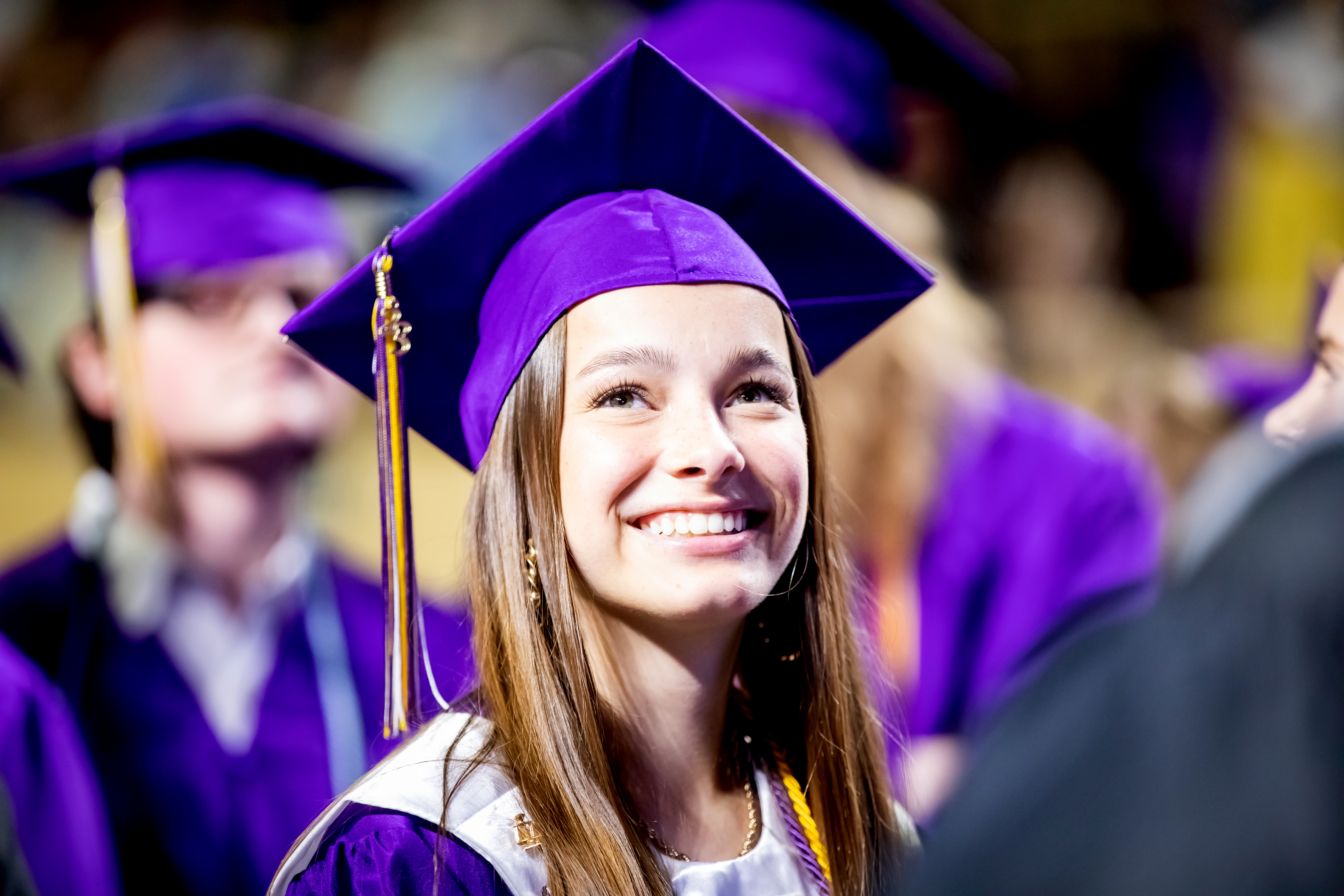Patrick Henry graduate smiles as she holds her diploma during the recessional.